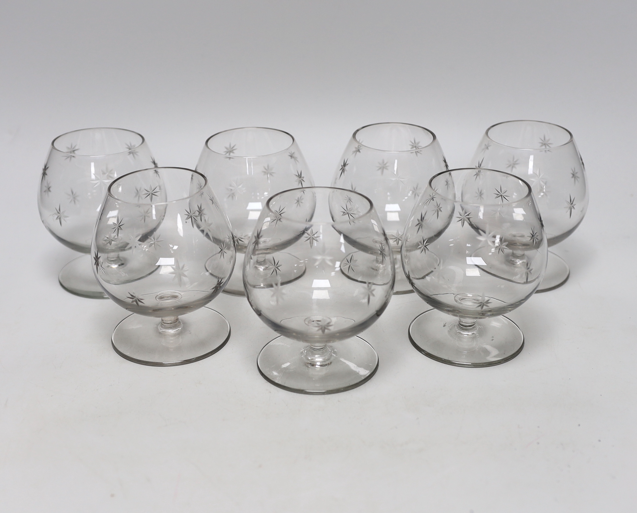 A set of seven cut glass brandy balloon glasses, with pattern of stars to each, 10.5cm high